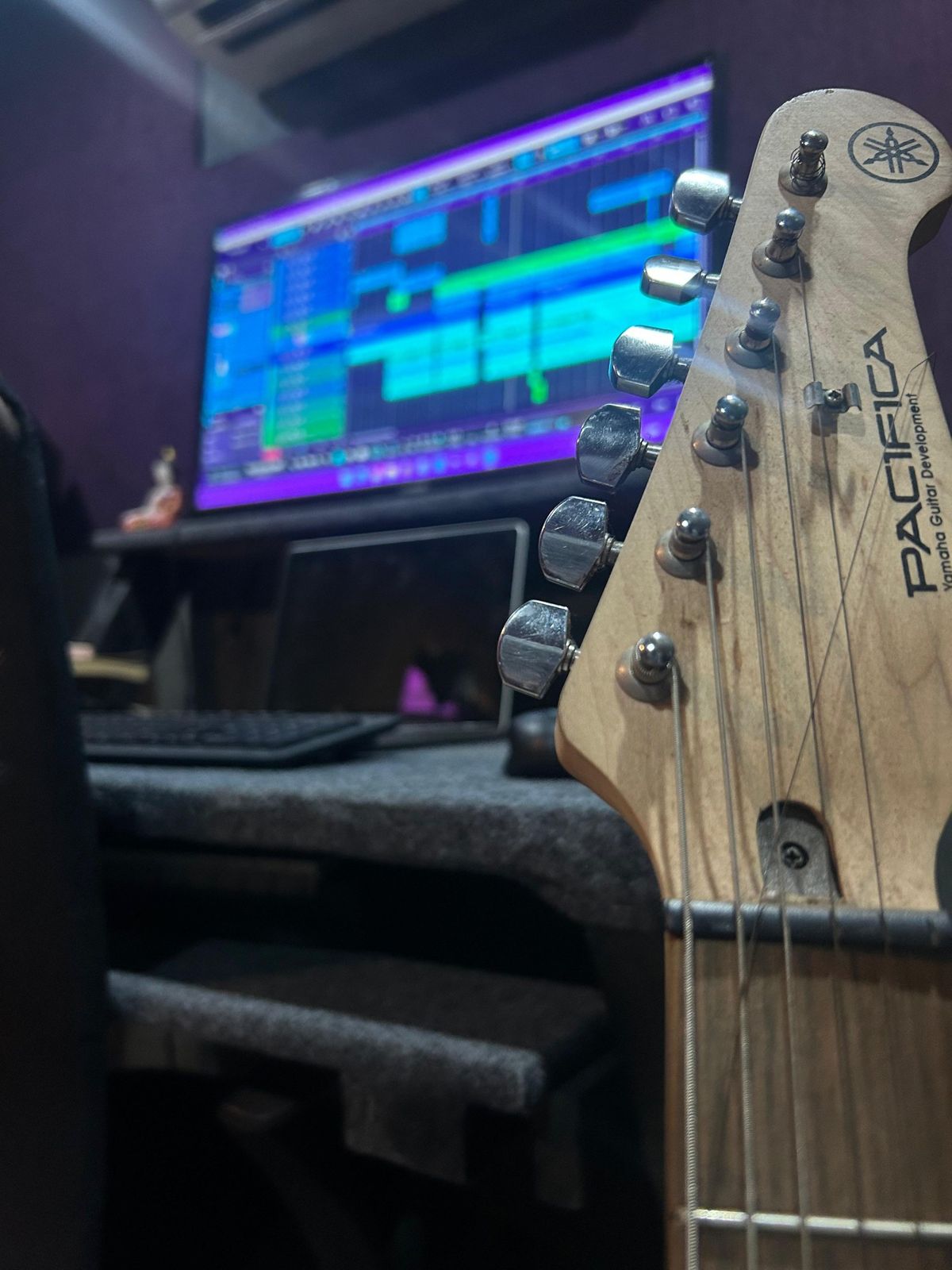 Guitar headstock in front of the DAW